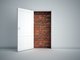 A white wall with an open door leading to a brick wall [Image by creator Mopic from AdobeStock]