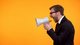 Business man yelling into a megaphone [Image by creator motortion from AdobeStock]