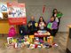 Photo of employees at Topline displaying items collected during their annual school supply drive [Image by creator  from ]